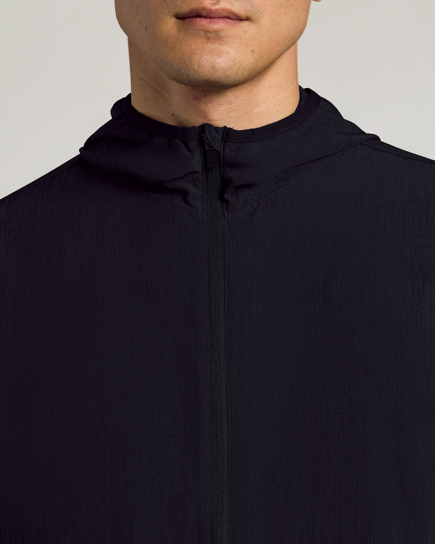 Black Active Shell Jacket with full zipper and hood, showcasing slim fit.