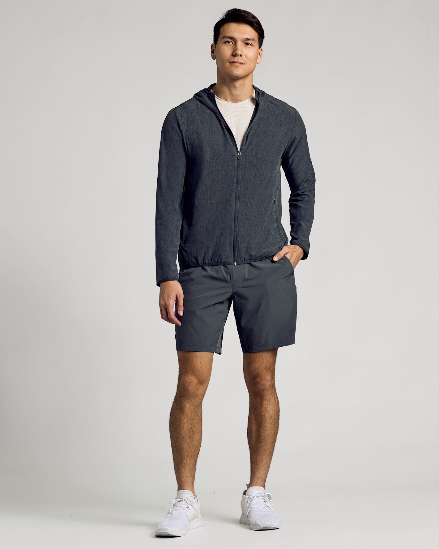 Young man models Charcoal Heather Gray Active Shell Jacket in athletic wear.