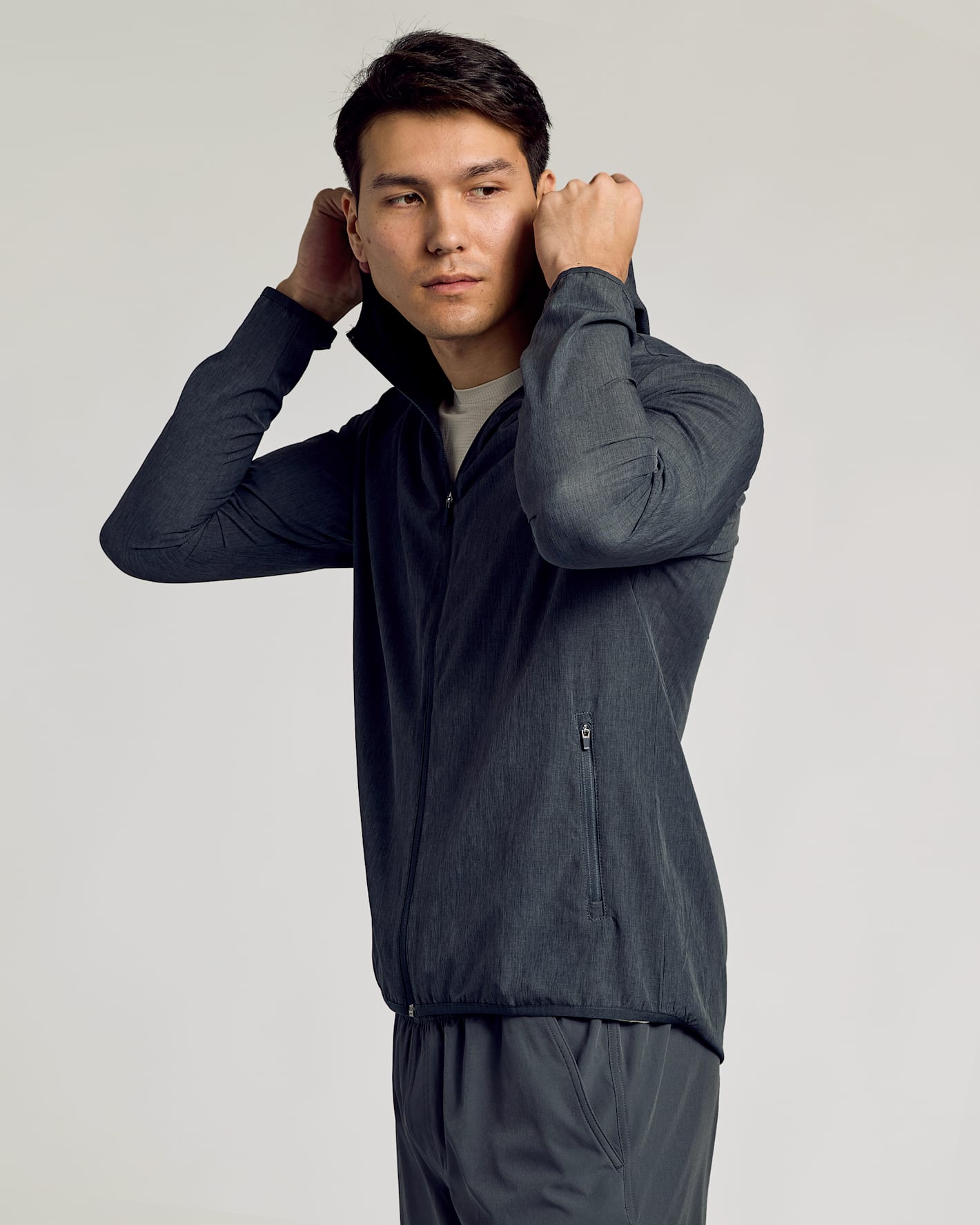 Young man in Charcoal Heather Gray Active Shell Jacket lifting hood.