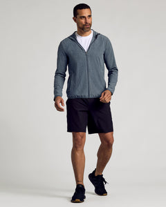 True ClassicMan walking in Heather Navy Active Shell Jacket with hood, shorts, and sneakers.