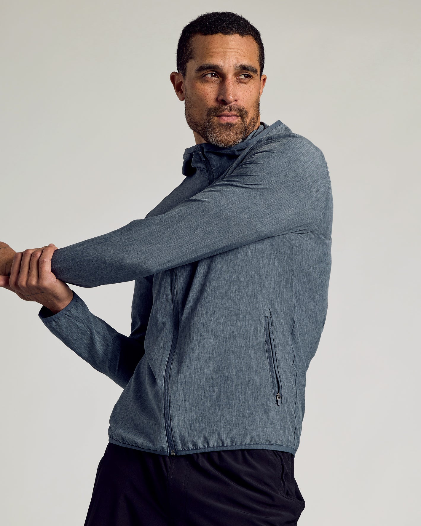 Man stretching in Heather Navy Active Shell Jacket.
