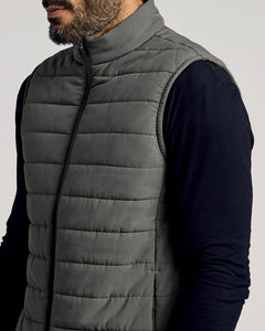 True ClassicMan wearing a gray Carbon Puffer Vest over a black long-sleeve shirt, featuring a high collar and horizontal quilted stitching.