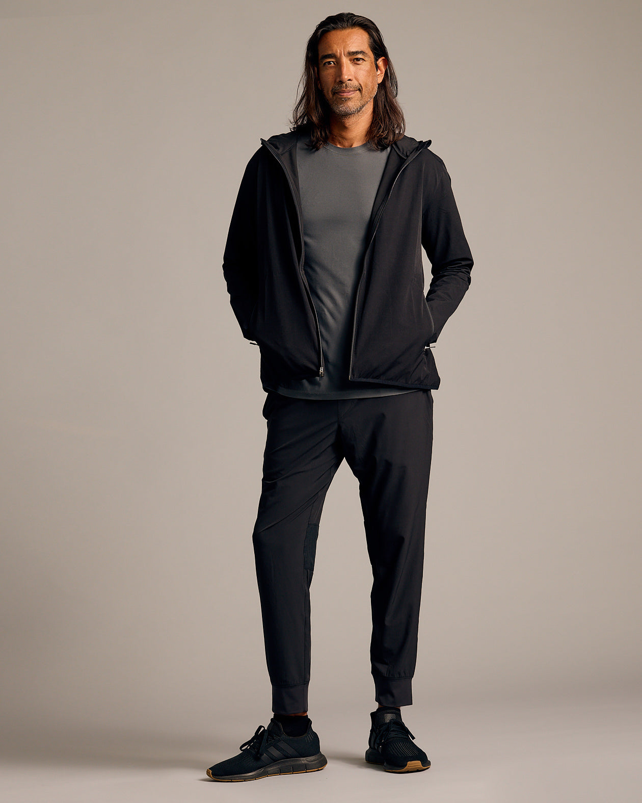 Black Tech Windbreaker worn by male model in athleisure outfit.