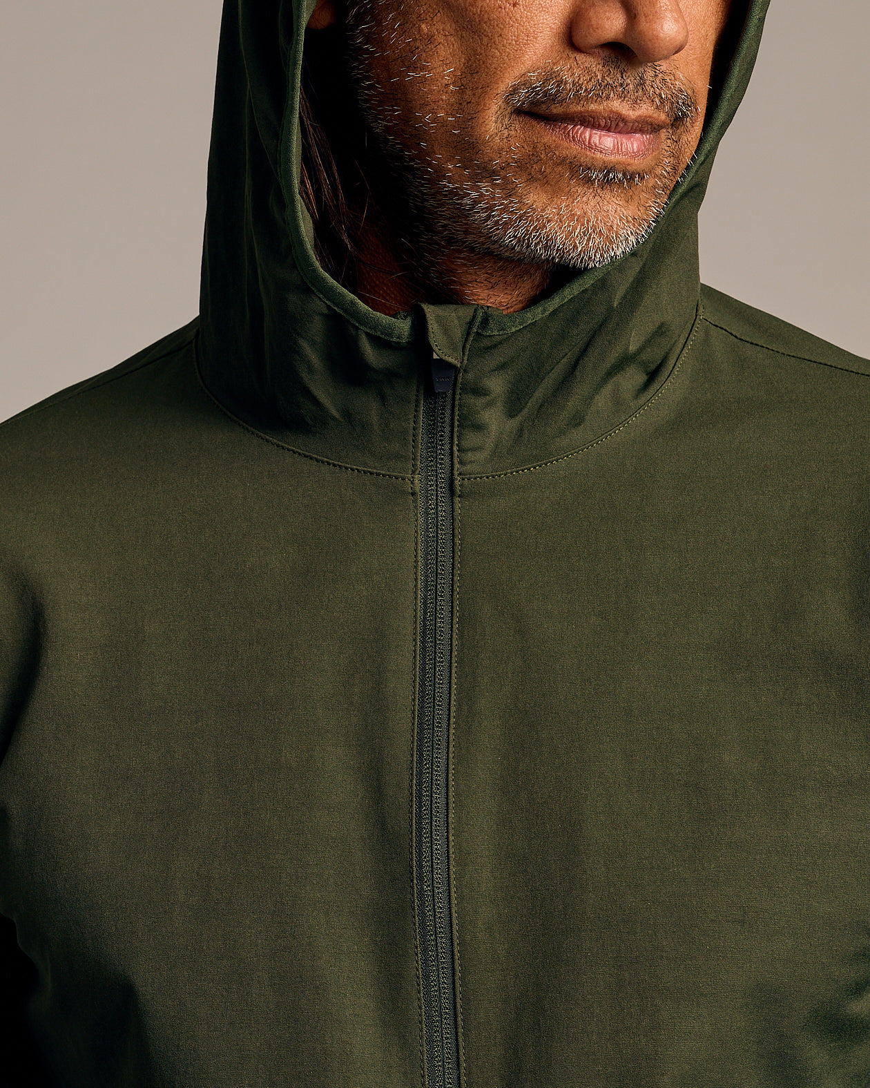 Olive Tech Windbreaker with hood and zipper shown on model.