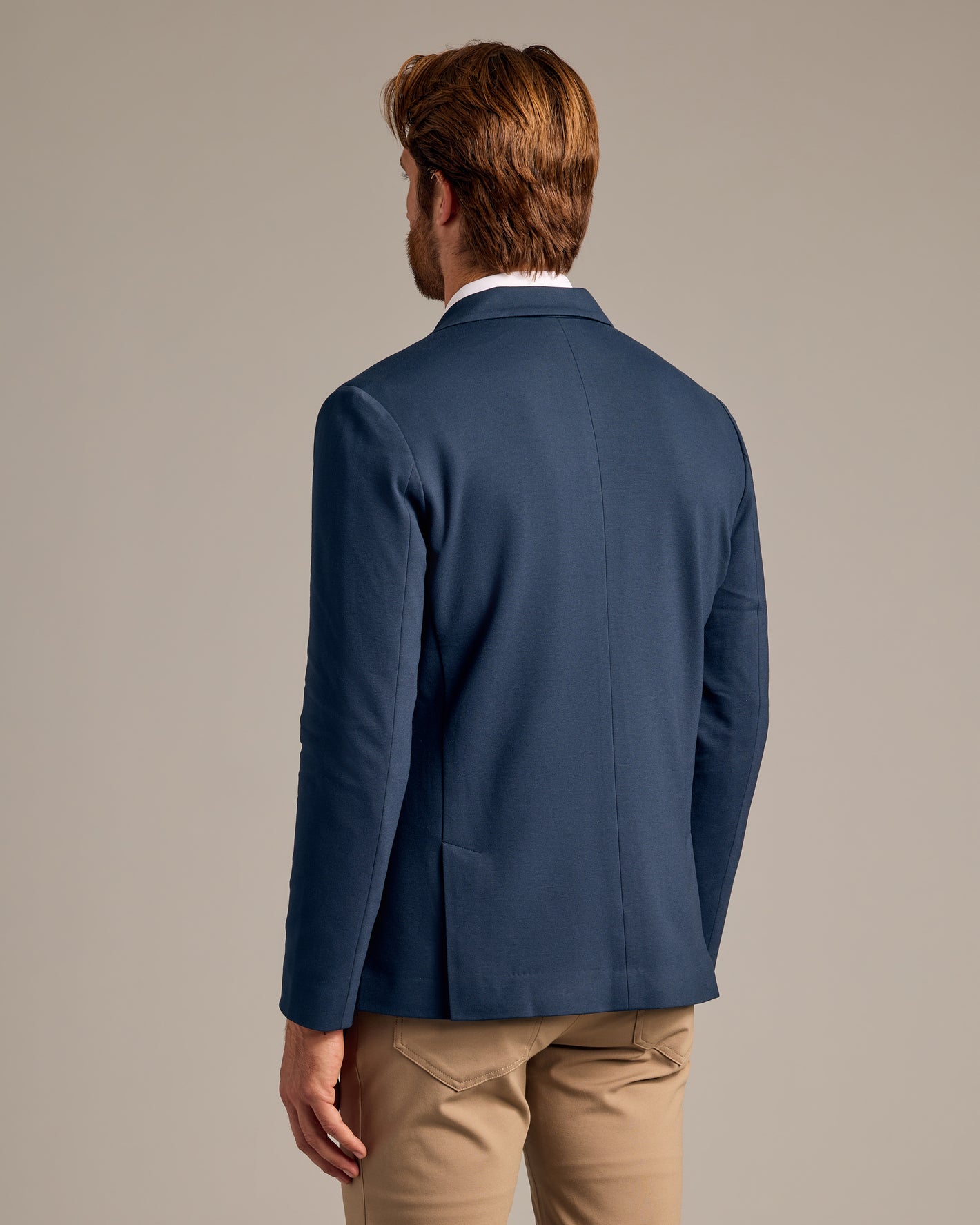 Navy Comfort Knit Blazer back view on model with khaki trousers.