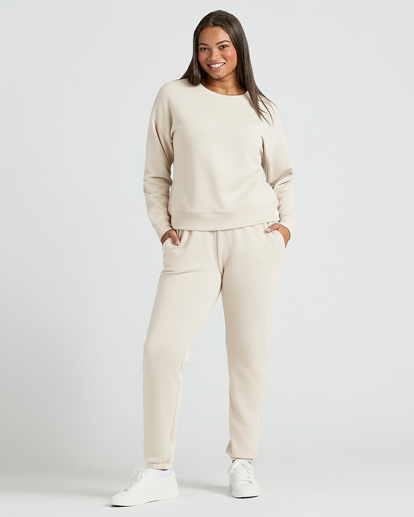 Woman in Womens Oatmeal Slouch Pullover Crew smiling, hands in pockets.