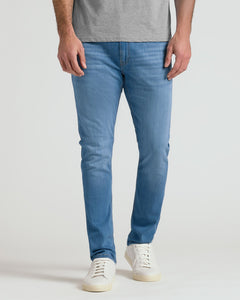 True ClassicA person wearing slim-fit blue jeans, a heather gray t-shirt, and white sneakers, shown from the waist down against a light gray studio background.