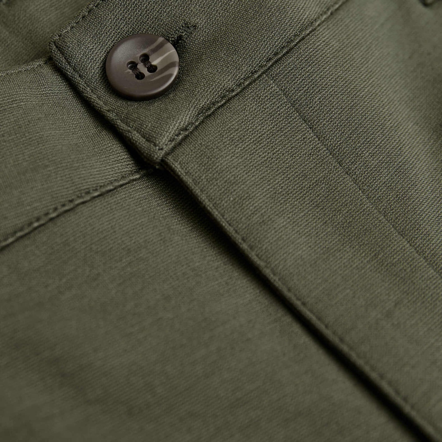 Military Green Slim Comfort Knit Chino Pant waistband close-up, showcasing button and fabric.