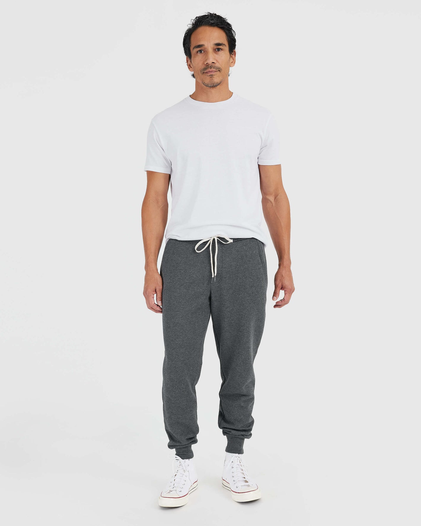 Man wearing Charcoal Heather Gray Fleece French Terry Joggers with white T-shirt.