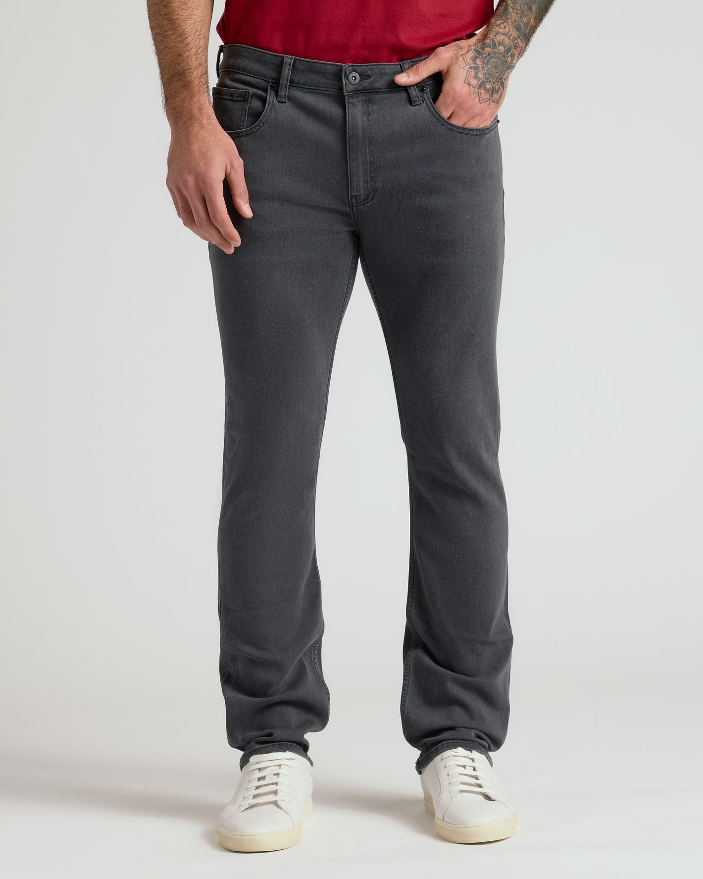 Carbon Bomber Jacket & Comfort Stretch Jeans modeled with sneakers, tattoo visible.
