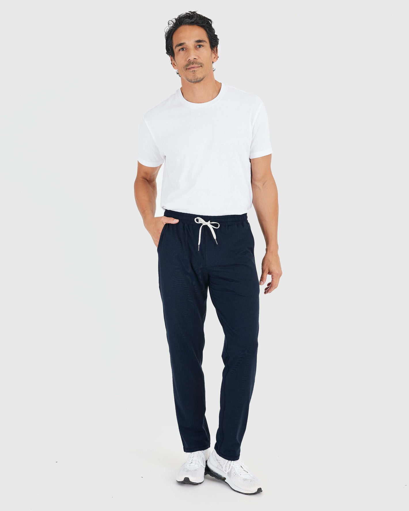 Man wearing Heather Navy Active Comfort Straight Leg Pant, white T-shirt, sneakers.