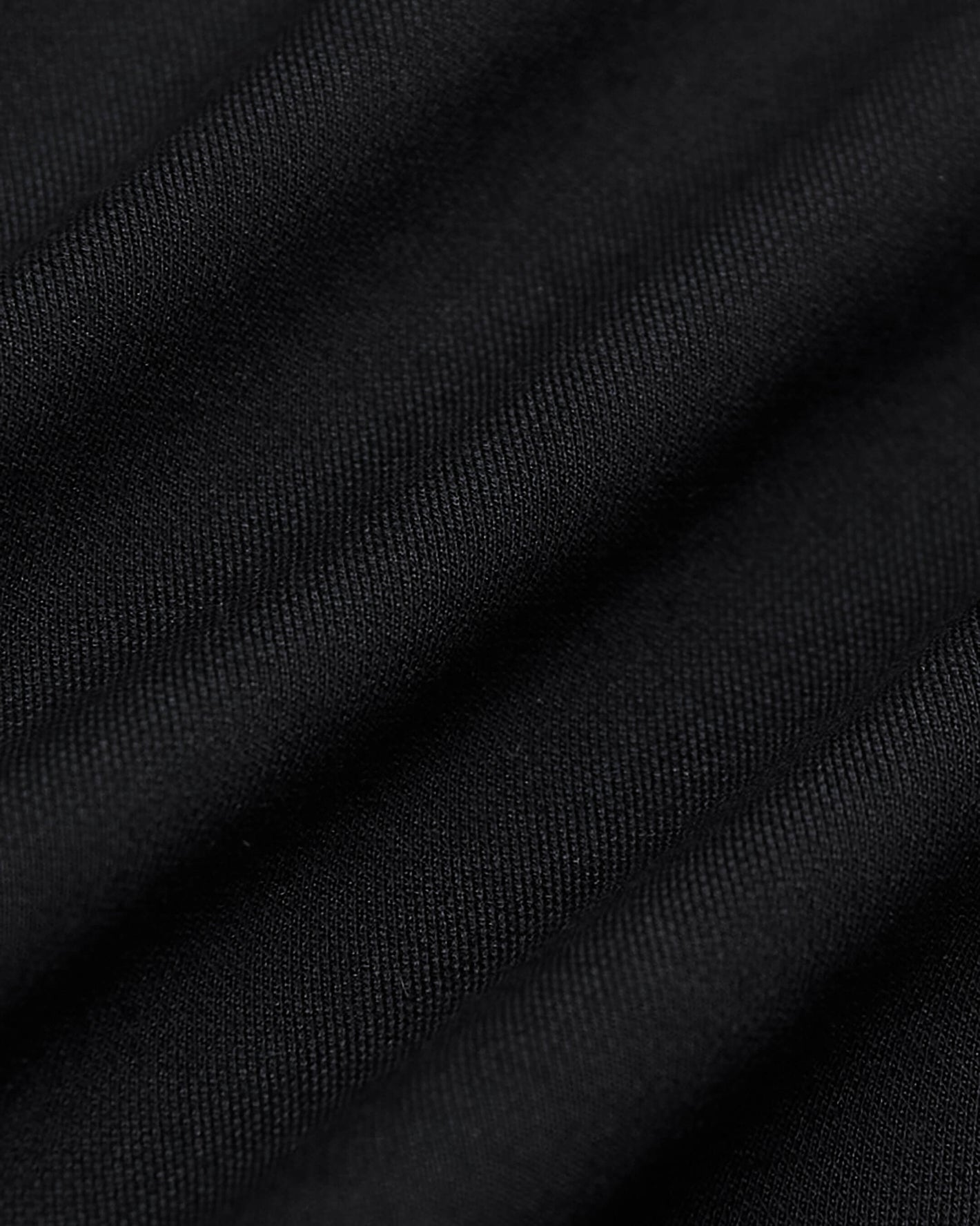 Black Commuter Pants fabric close-up showing fine weave texture and folds.