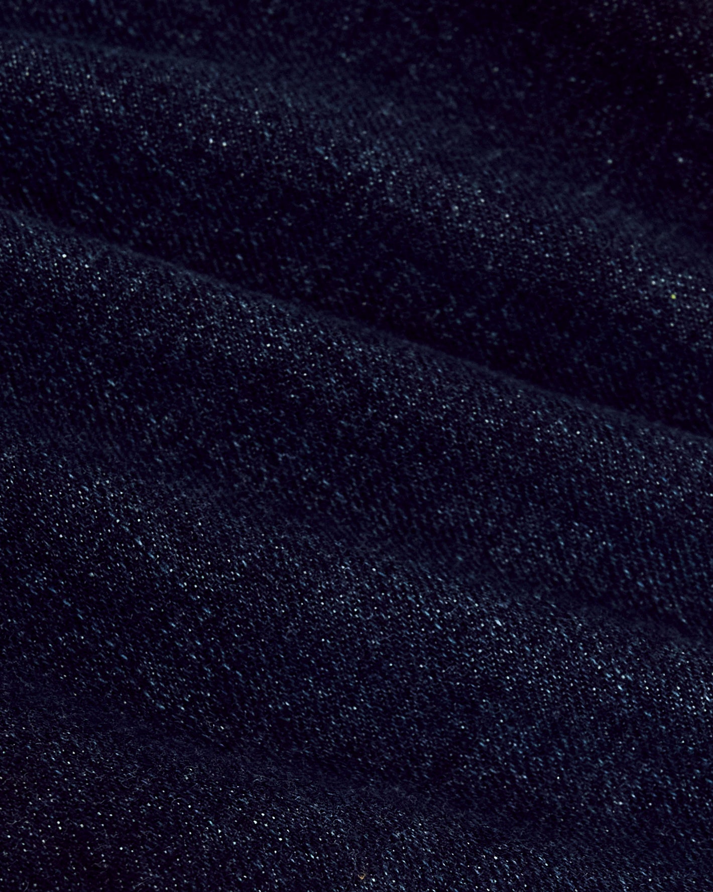 Indigo Rinse Slim Authentic Denim Jeans close-up, showcasing durable fabric folds.
