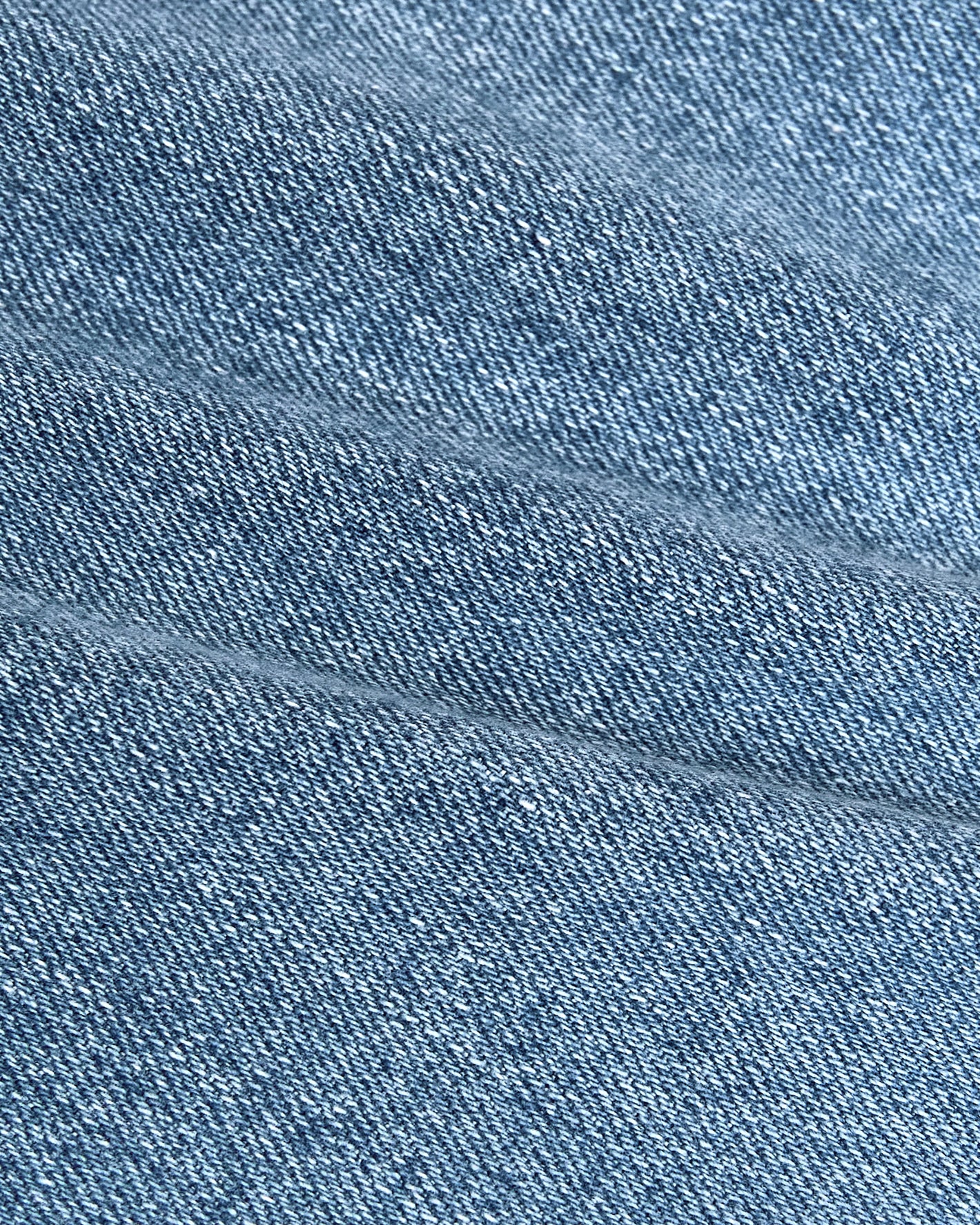 Light Indigo Wash Straight Authentic Denim Jeans close-up, showing woven texture and seam.