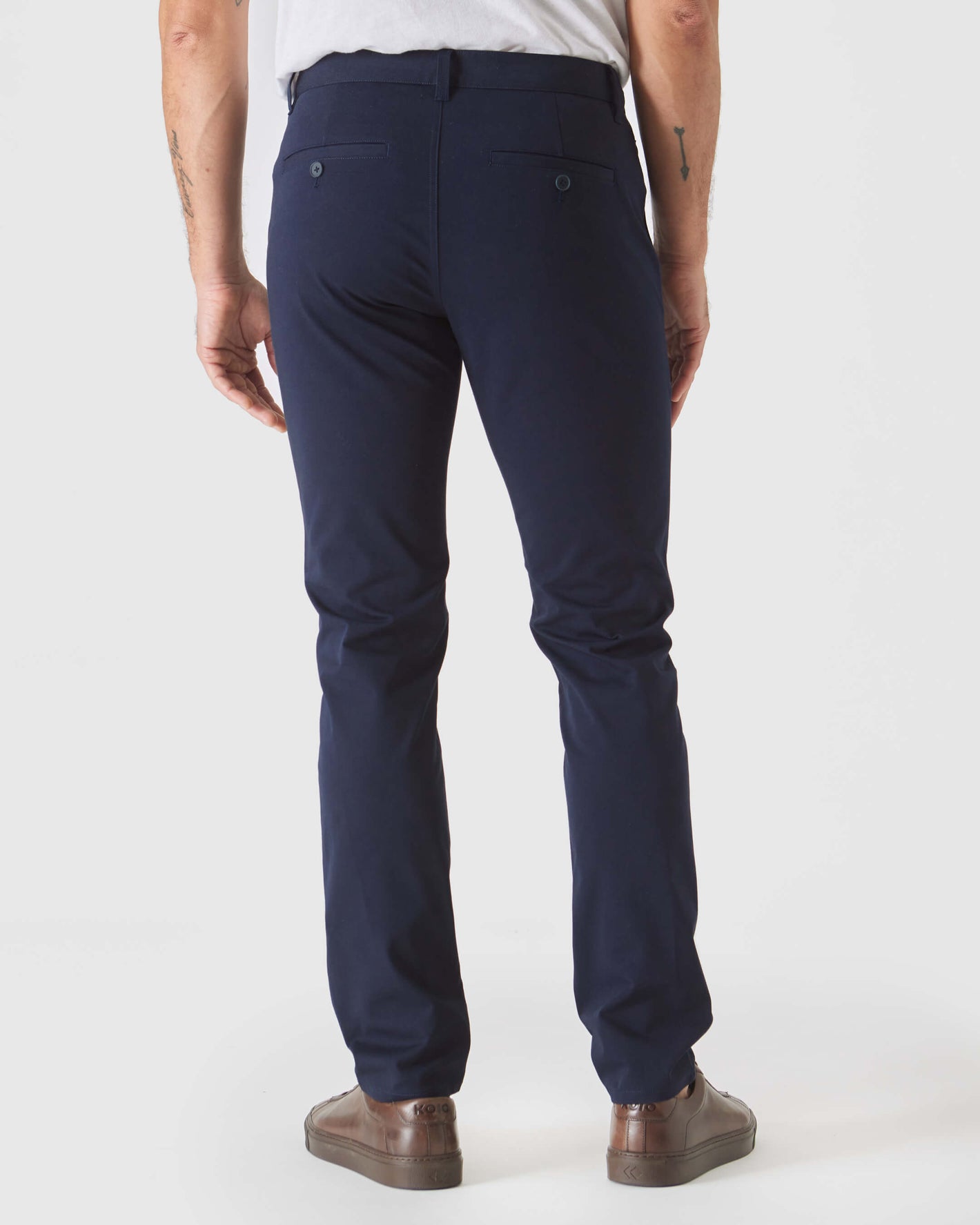 Navy Slim Twill Chino Pant shown from the back with sneakers.