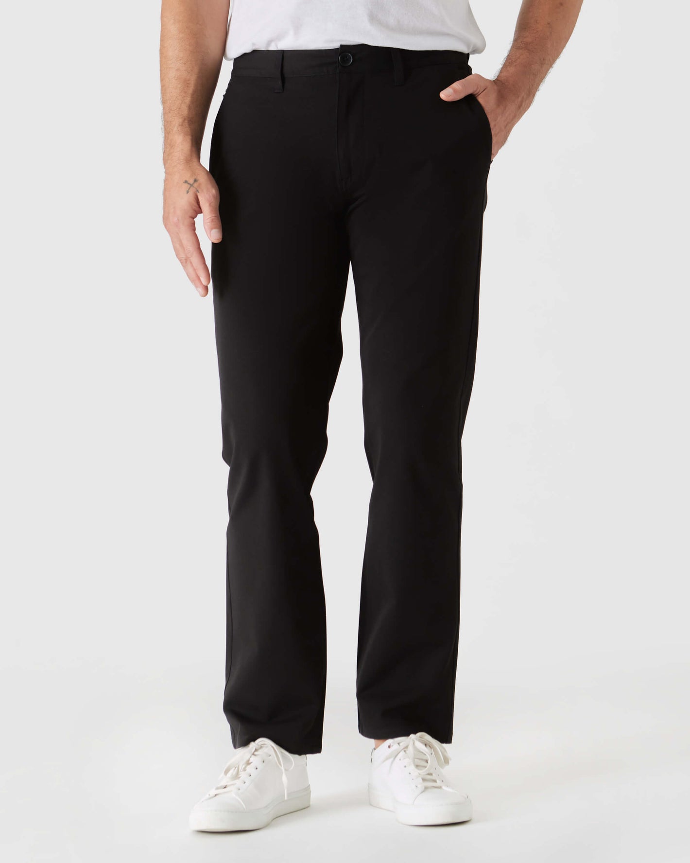 Black Straight Twill Chino Pant with white sneakers, hand in pocket.