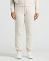 Womens Oatmeal Relaxed Joggers with elastic cuffs and white sneakers.