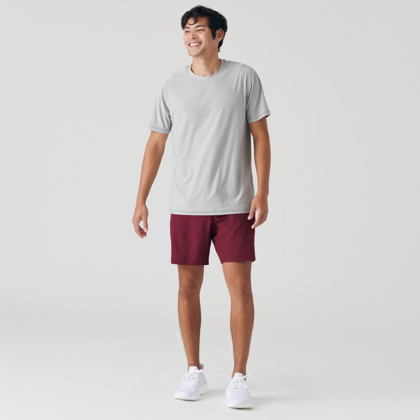 Burgundy Active Performance Short Outlet worn by smiling man, studio-style shot.