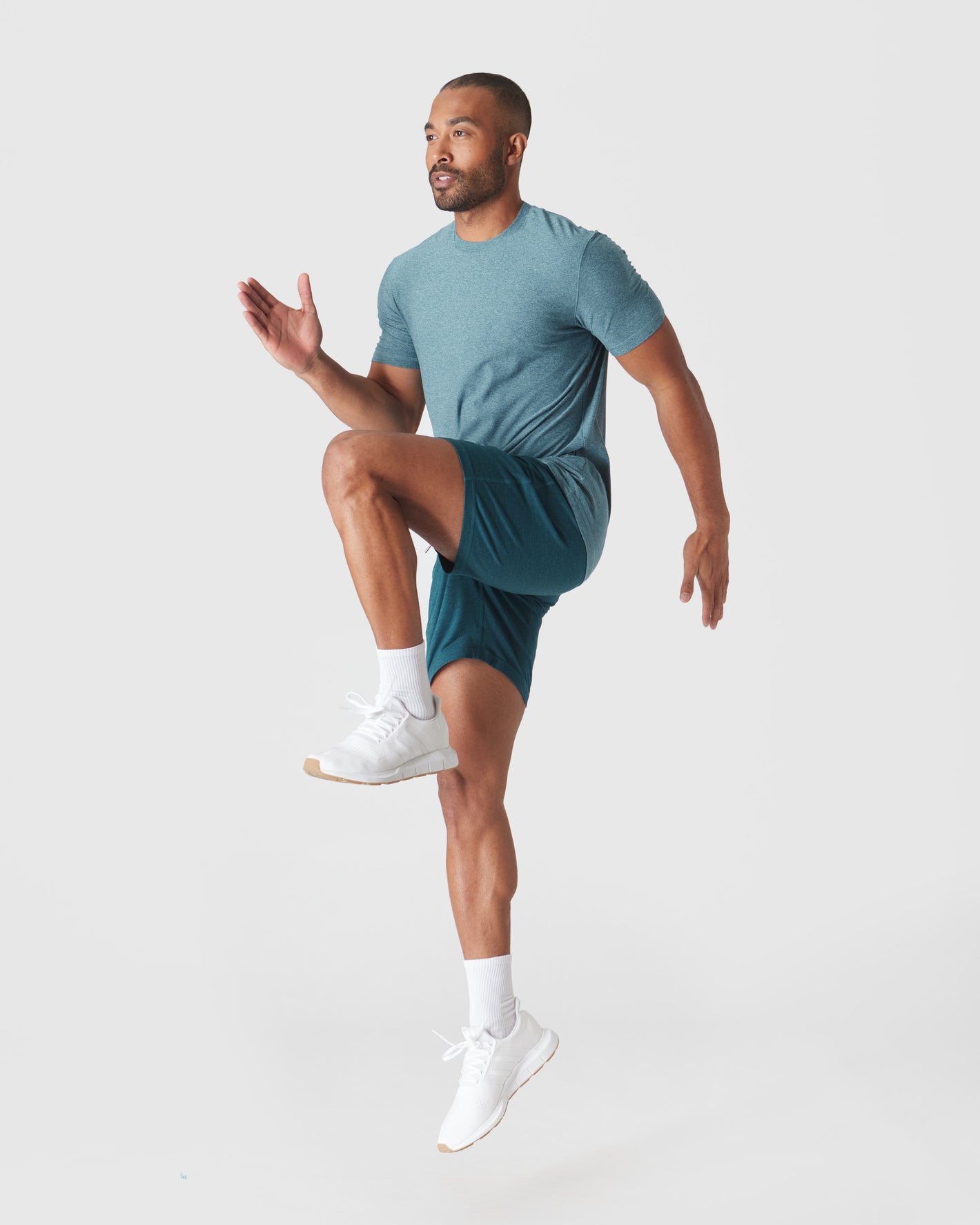 Athletic man wearing Dark Heather Centurion Active Comfort Shorts mid-air.