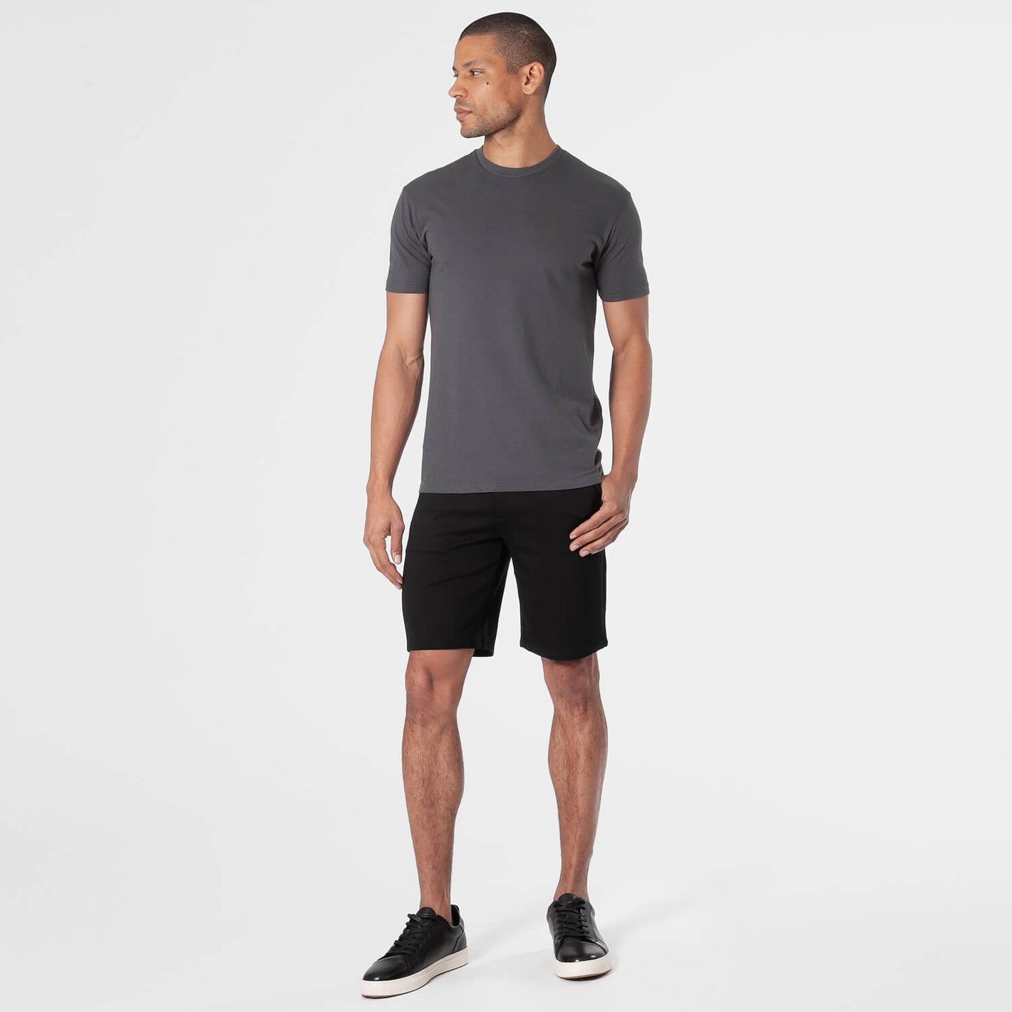 Man wearing 9 Black Comfort Knit Chino Shorts, looking left.