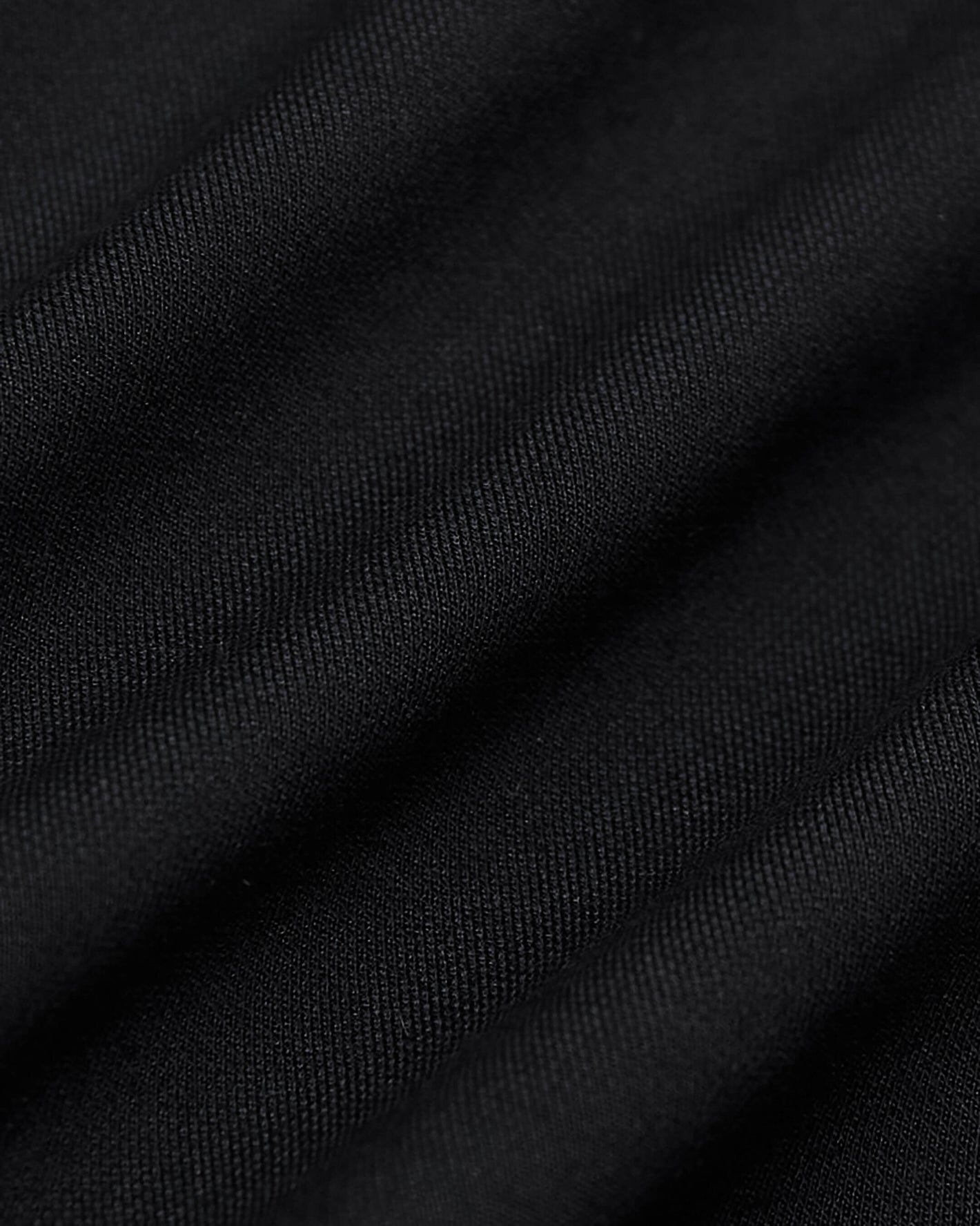 Black Commuter Short fabric close-up, highlighting fine woven texture and soft folds.