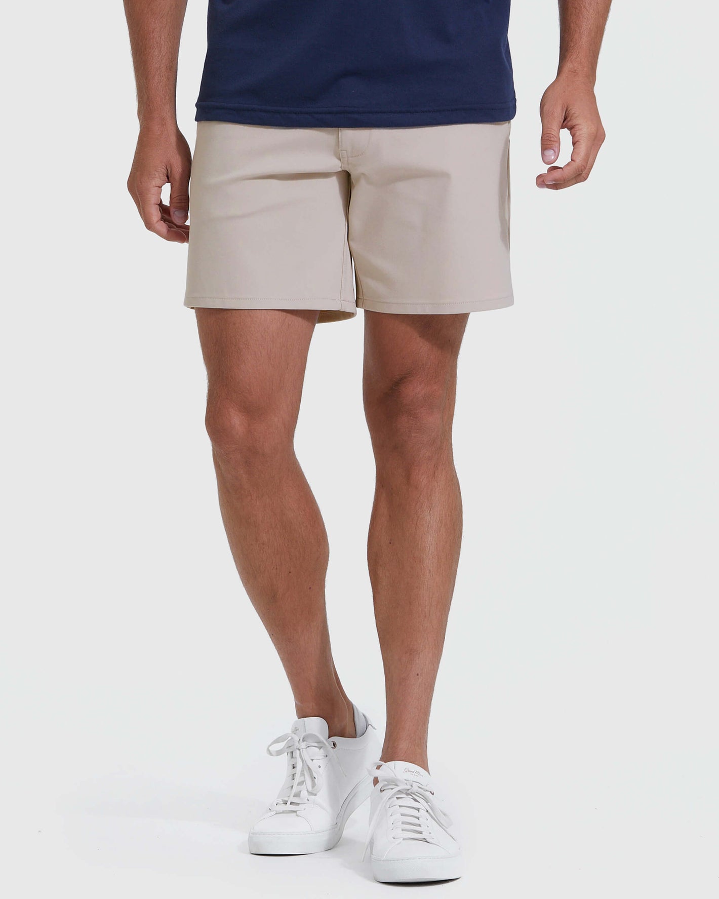 Man wearing Sandstone Commuter Short and white sneakers, showcasing slim fit.