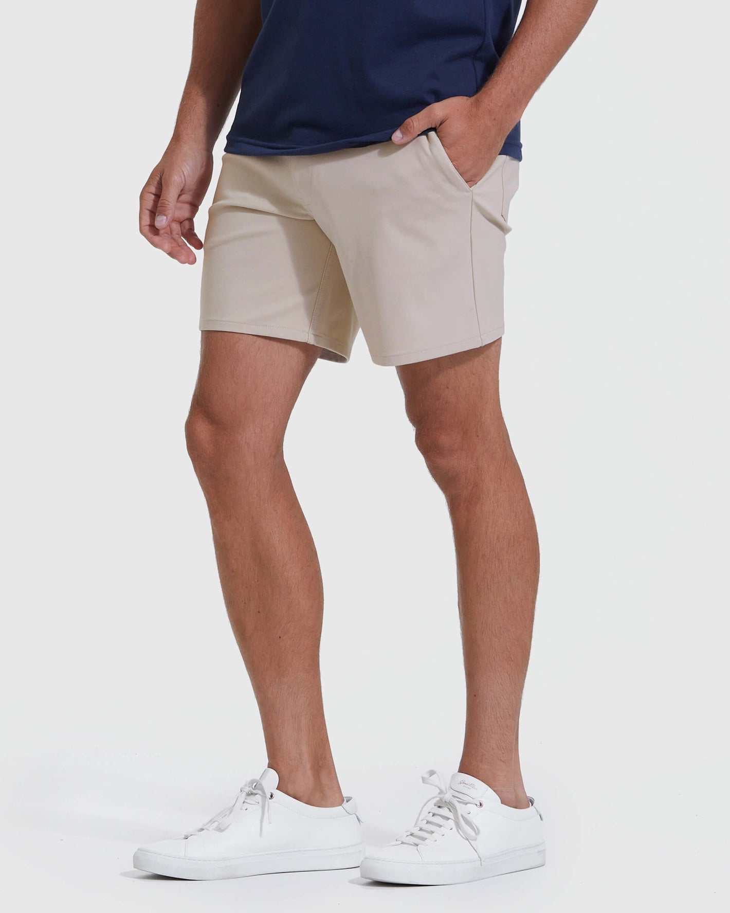 Man wearing Sandstone Commuter Short with white sneakers, hand in pocket.