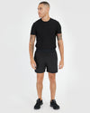 7 Black Active Training Shorts 2.0 on tattooed male model, casual stance.