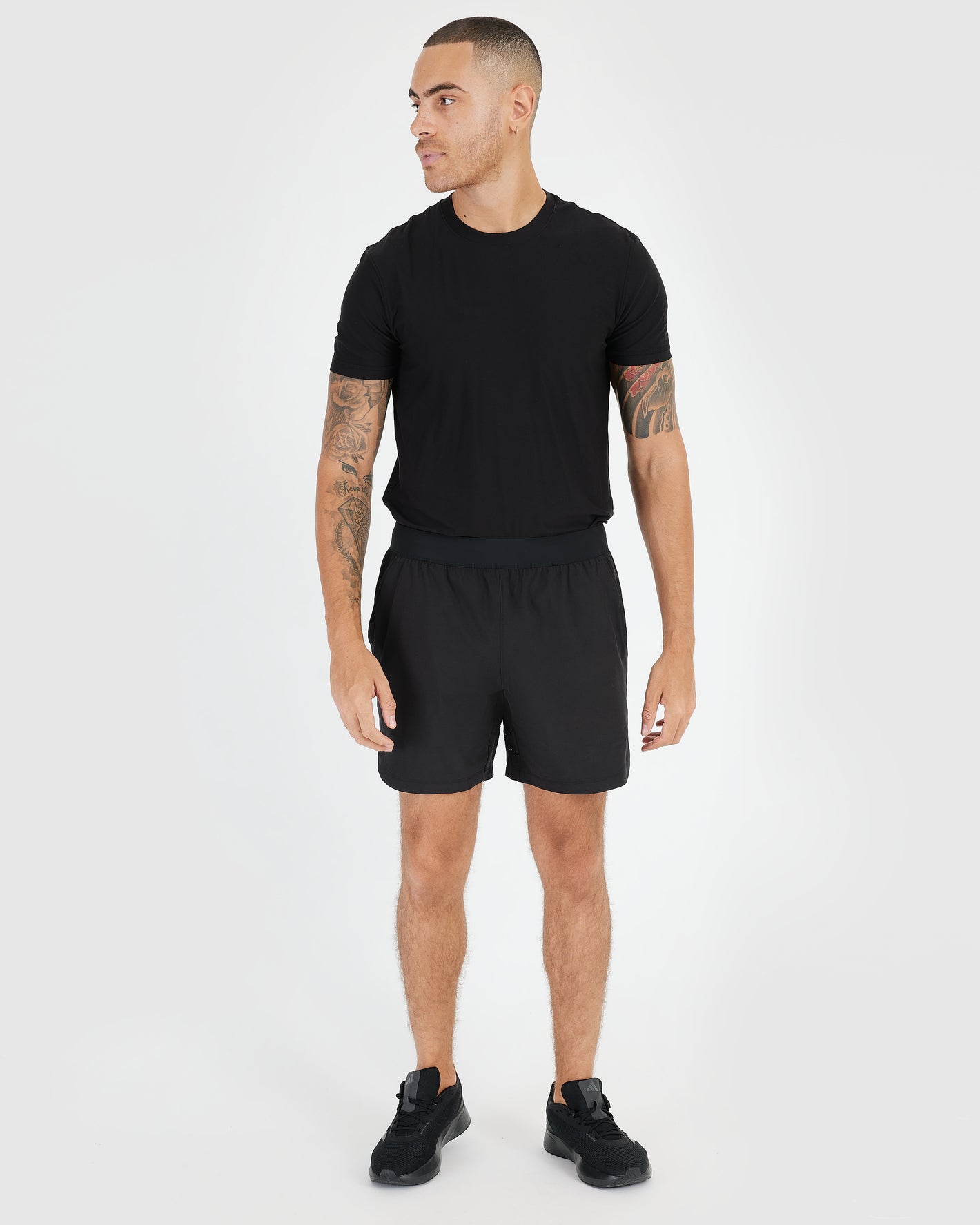 7 Black Active Training Shorts 2.0 on tattooed male model, casual stance.