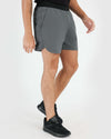 7 Carbon Active Training Short with black waistband, black shoes, white background.