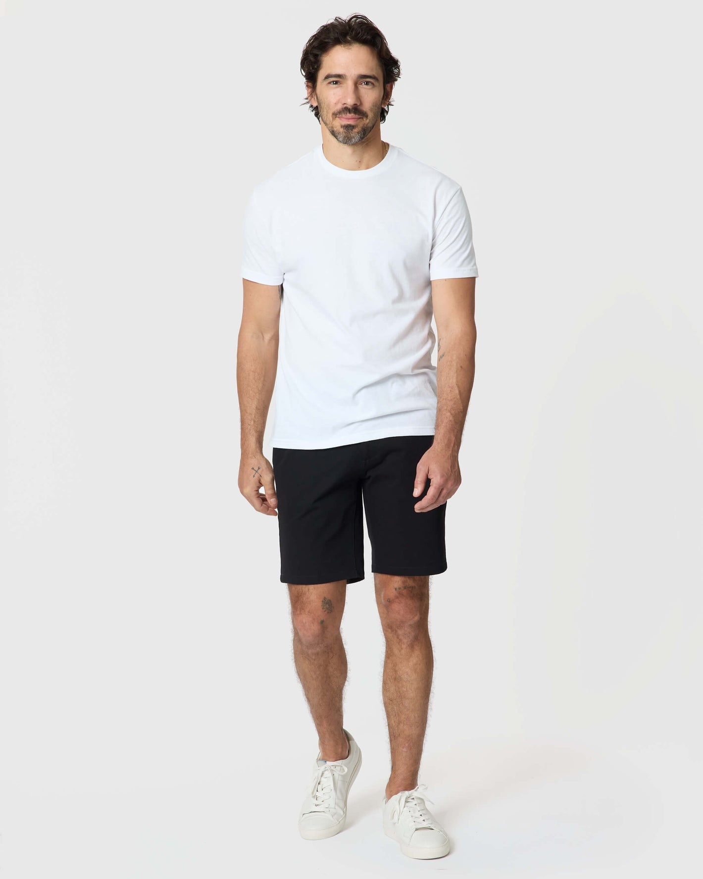 Man wearing 9 Black Classic Twill Shorts, white tee, sneakers.