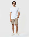 Man wearing Khaki Twill Short, white T-shirt, sneakers; casual, structured style.