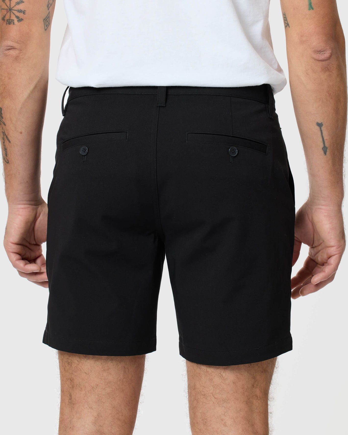 Man wearing 7 Black Classic Twill Shorts with buttoned back pockets.