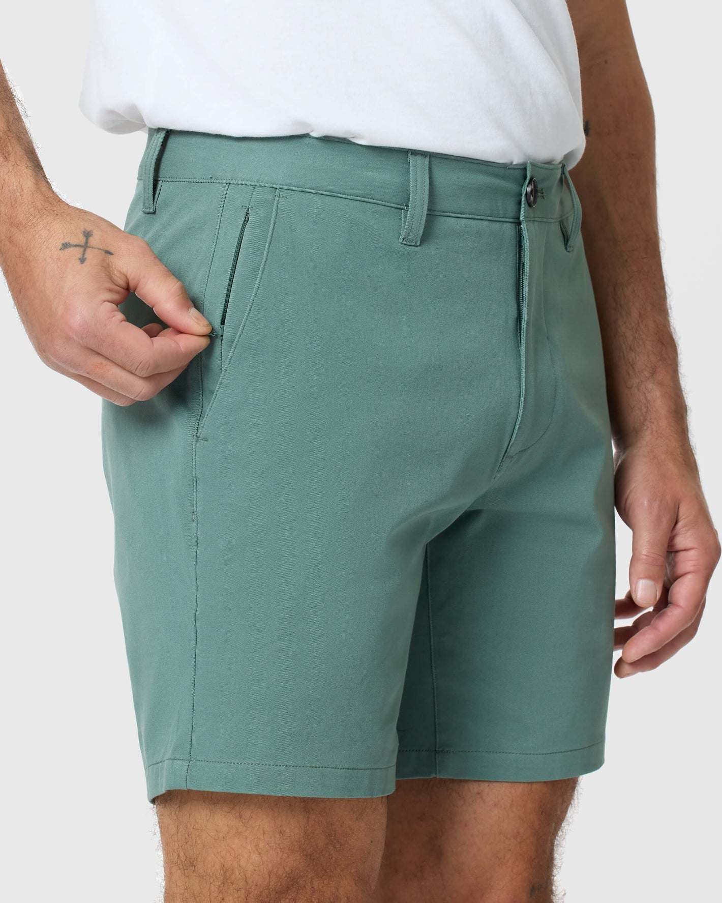 Person wearing 7 Moss Classic Twill Shorts with zippered pocket open.