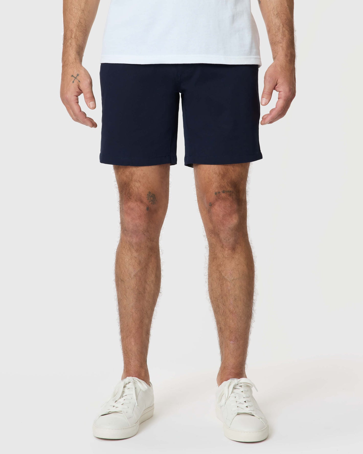 Model wearing 7 Navy Classic Twill Shorts with white sneakers.