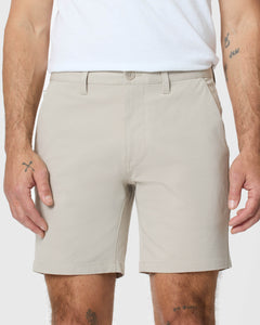 True Classic7 Sandstone Classic Twill Shorts on tattooed model's legs and forearms.