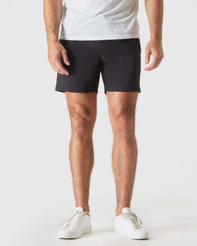 Black Swim Trunk, athletic style, with sneakers and small visible tattoos.