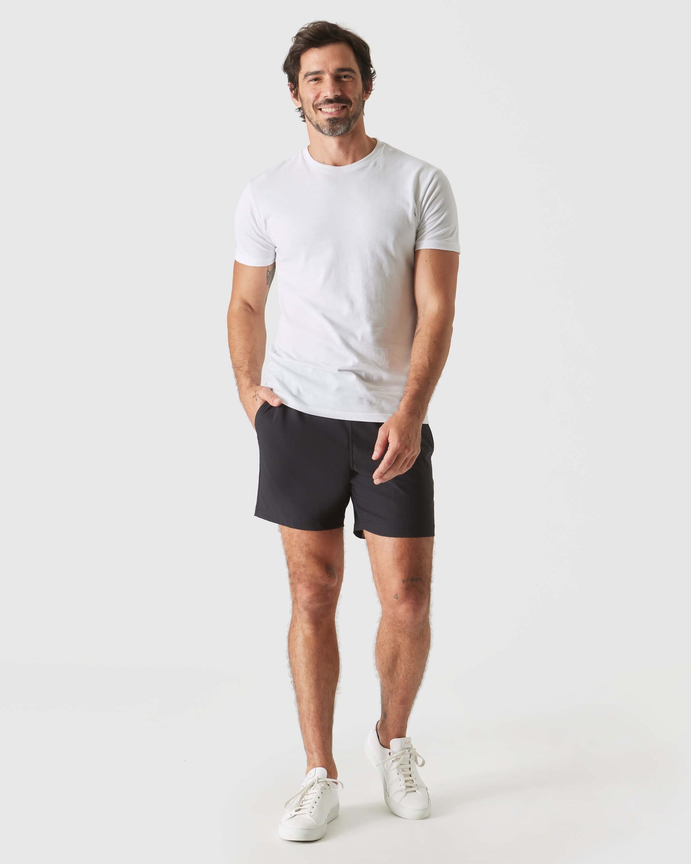 Man wearing Black Swim Trunk with white T-shirt and sneakers.