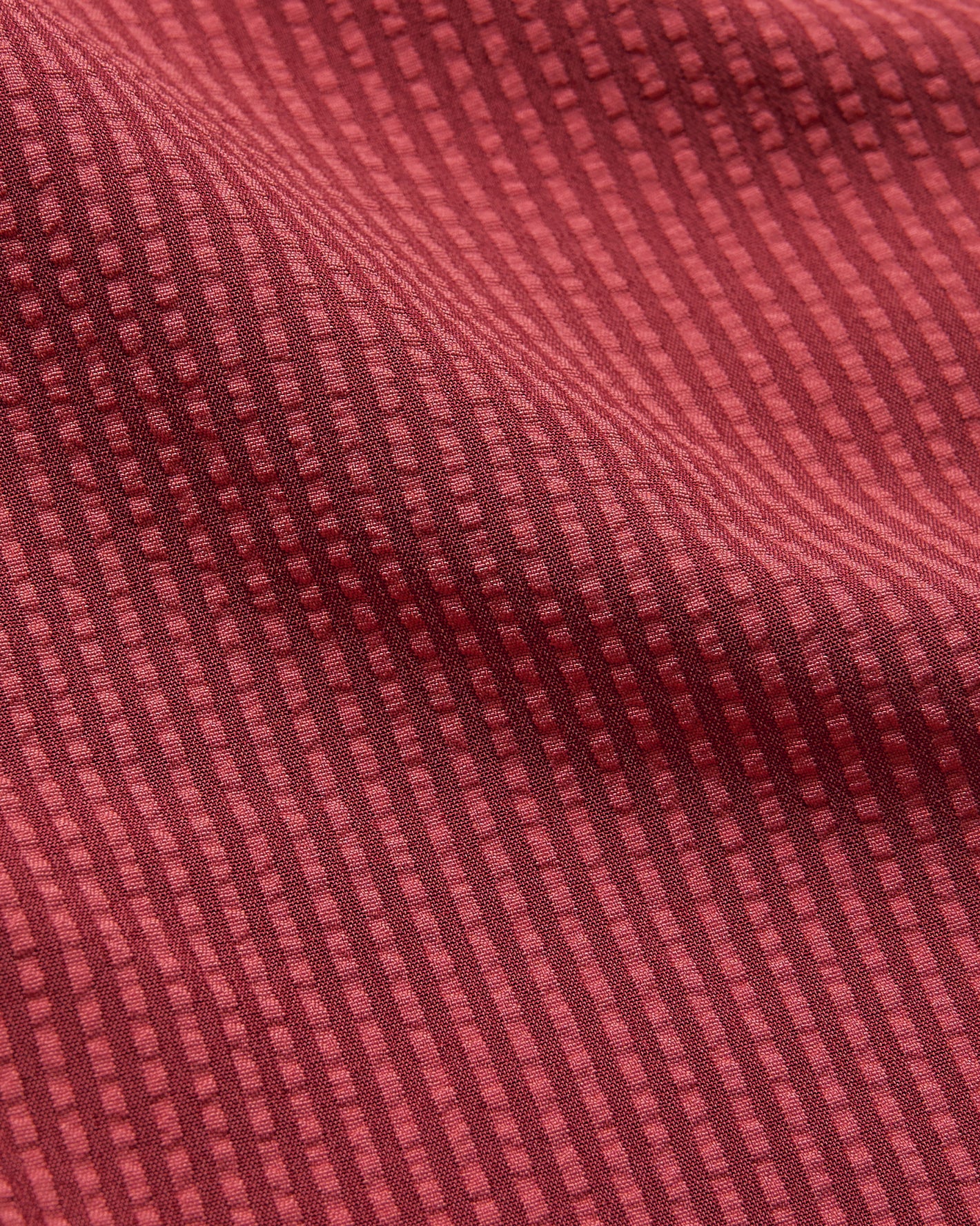 5 Cardinal Seersucker Swim Trunks with textured, ribbed red fabric pattern.