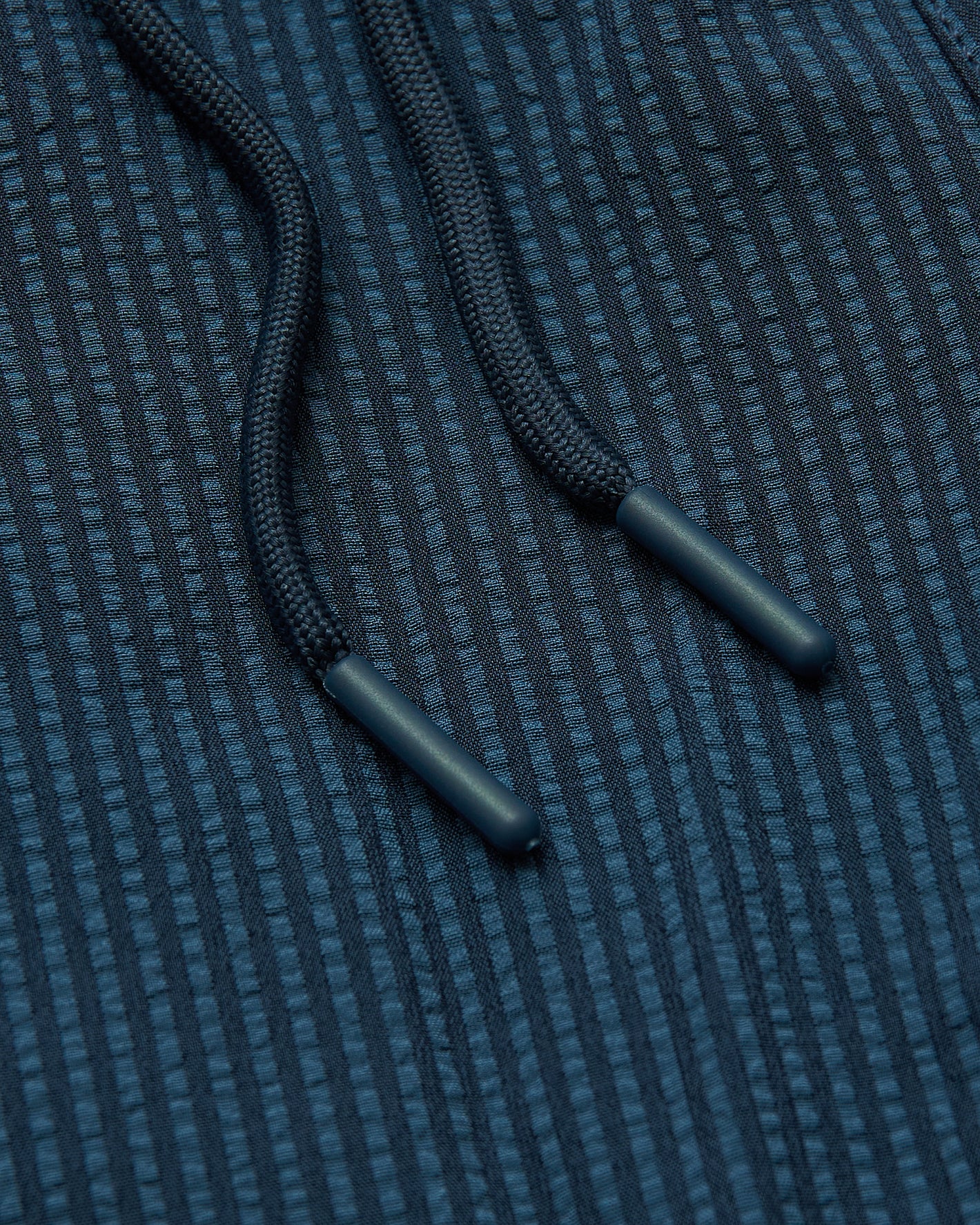 5 Underwater Seersucker Swim Trunks' blue braided drawcords on textured fabric.