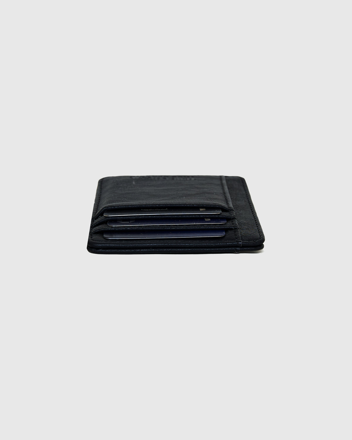 Black Classic Wallet on gray surface, showcasing card slots with cards.