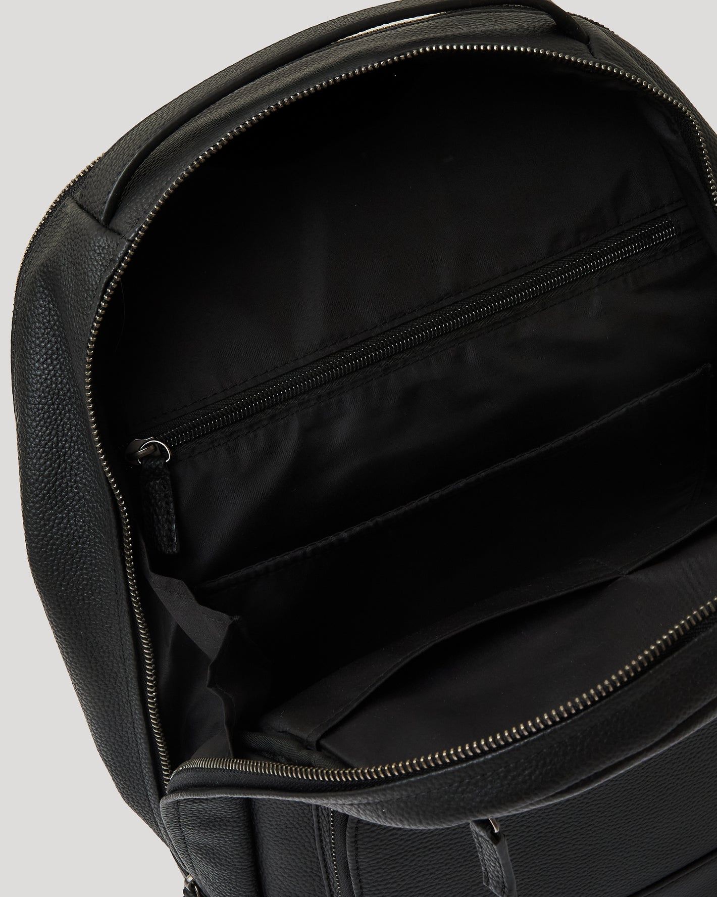 Premium Leather Backpack's interior with main compartment, zip pocket, and slip pockets.
