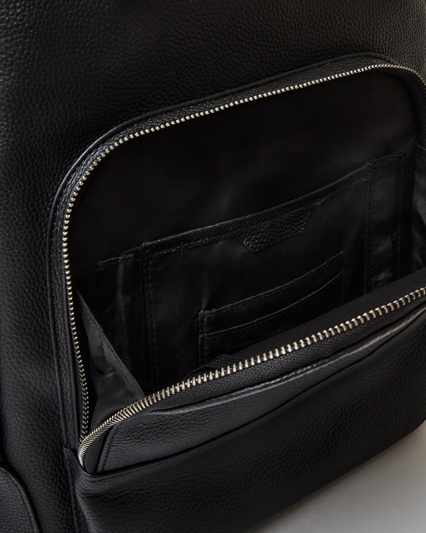 Premium Leather Backpack with open front pocket showing internal compartments.