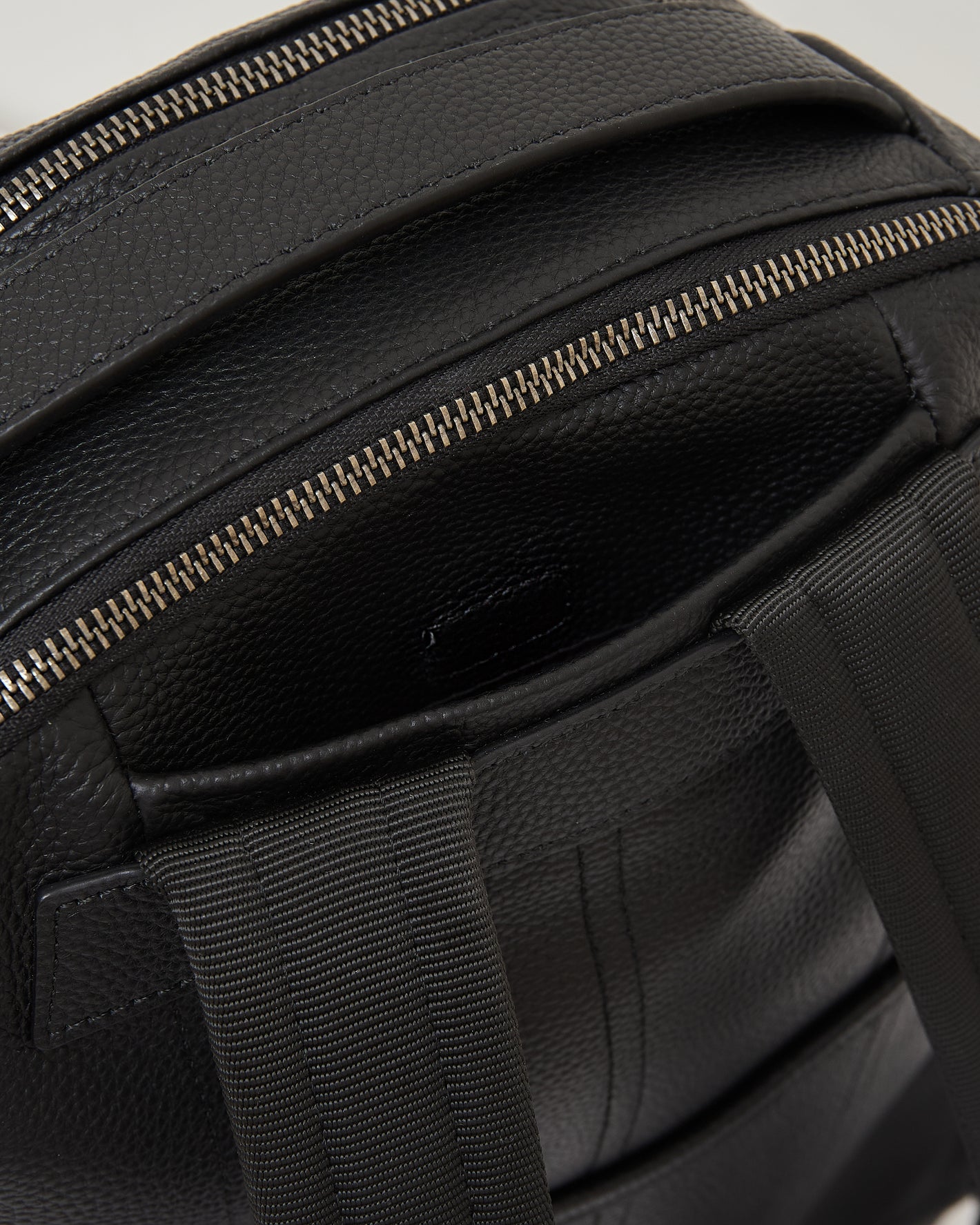 Premium Leather Backpack showing textured leather, metal zipper, and shoulder straps.