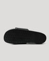 Black Comfort Slides' outsole with textured rubber tread pattern for grip.