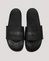 Black Comfort Slides with TRUE CLASSIC embossed strap, side by side.