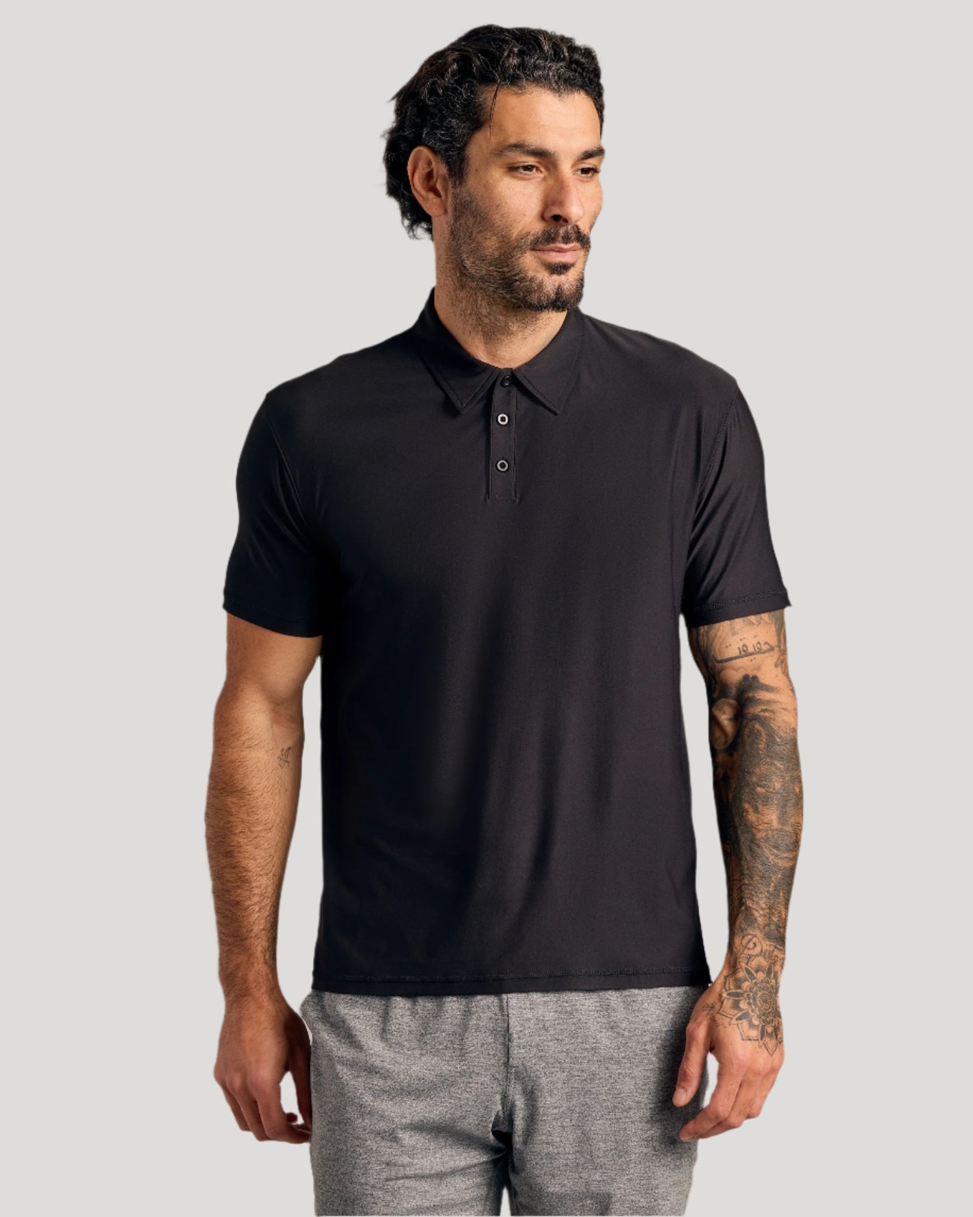 Man models Black & White Active Polo, showcasing its athletic fit and style.