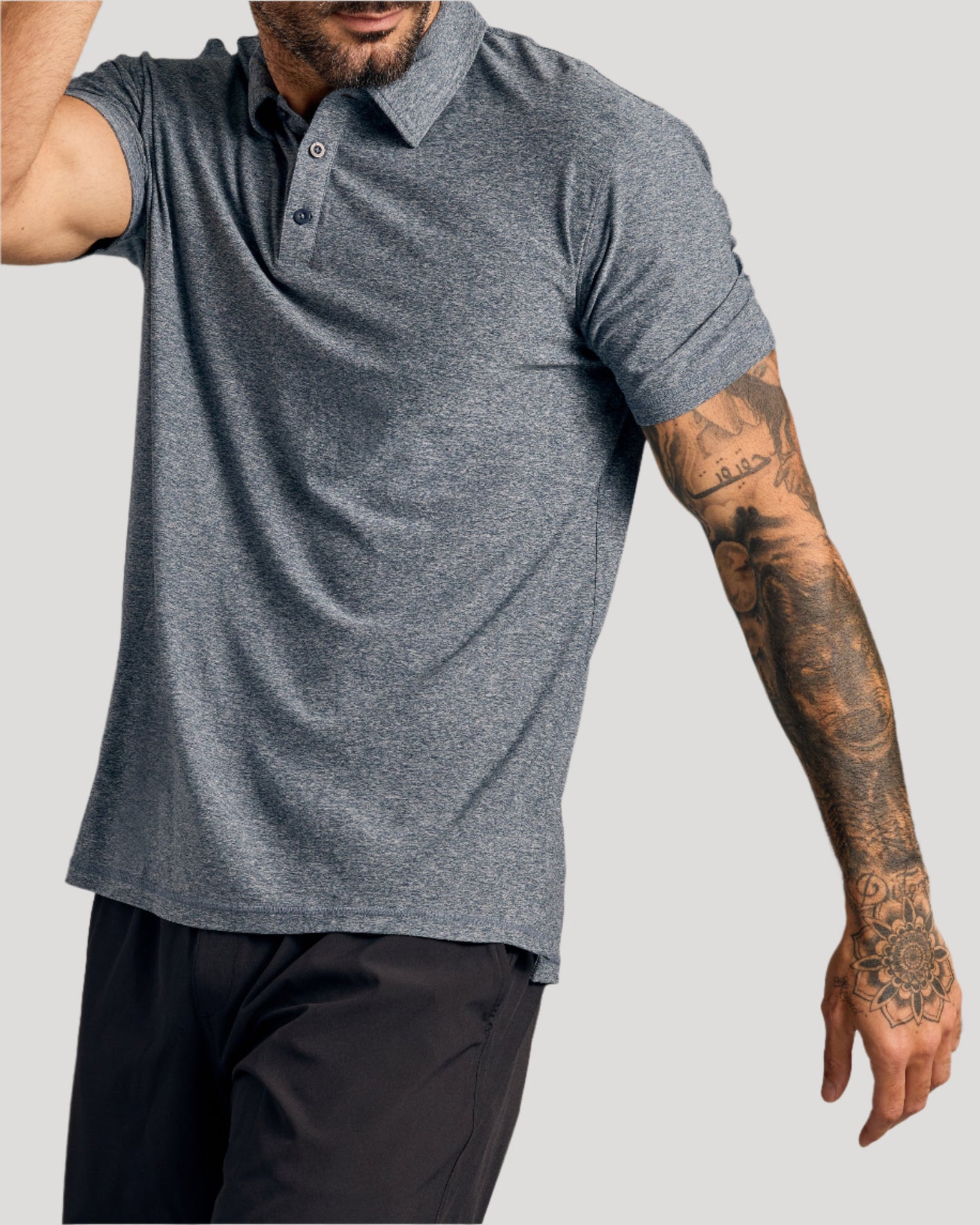 Man in Heather Gray Short Sleeve Active Polo with tattooed arm.