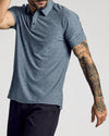 Man wearing Heather Navy Active Short Sleeve Polo, showcasing tattooed arm.
