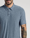 Man wearing Heather Navy Active Short Sleeve Polo, tattooed forearm visible.